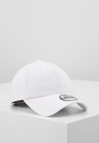 Weiße Baseballkappe aus Stoff mit einem gebogenen Schirm, vorne mit einem runden Logo-Patch, glatte Textur und gestickte Details.