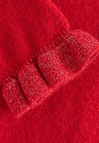 Rode gebreide trui met een gestructureerde ribbelmanchet, gemaakt van een zacht materiaal met subtiele glinsterende details in het garen.