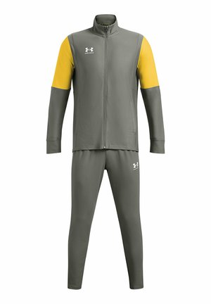 Survêtement de sport gris avec des accents jaunes. Veste zippée avec col haut et pantalon assorti en gris. Présente le logo Under Armour.