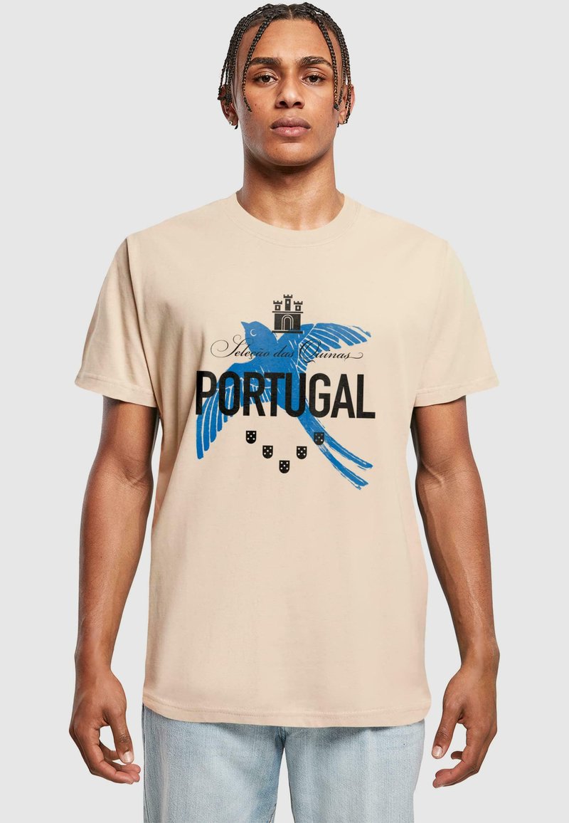 Bežinis medvilninis marškinėliai su mėlynu paukščio piešiniu, juodu tekstu "PORTUGALIJA" ir dekoratyviniais elementais, tokiais kaip karūnos ir skydai.