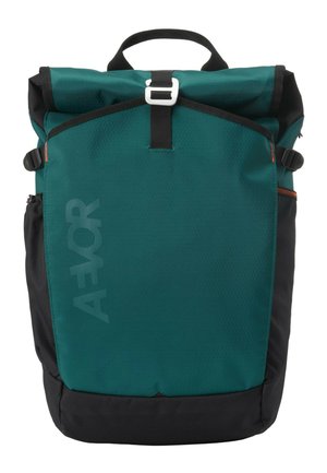 Türkis-schwarzer Rolltop-Rucksack mit Frontverschluss, Seitentaschen, Tragegriff oben und dezentem "AEVOR"-Branding auf der Frontplatte.