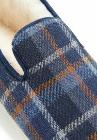 Marinefarbene Karoplitschen mit orangefarbenen und grauen Akzenten, weicher weißer Innenausstattung und runder Form, die an der oberen Seite einen Ausschnitt aufweist.