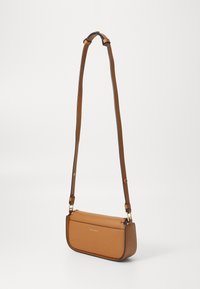 Hnědá kožená crossbody taška obdélníkového tvaru, s nastavitelným popruhem, zlatými akcenty a hladkou texturou. Na přední straně se nachází logo.