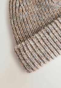 Knit beanie featuring a blend of tan, gray, and white yarn. Ribbed texture with a folded cuff and layered stitching patterns.
