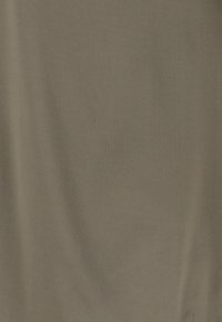 Brun, mjuk tyg med en slät yta, som hänger ner med subtila veck. Inga synliga mönster eller beslag.