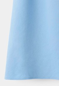 Tissu bleu clair avec une texture visible et un ourlet cousu sur le bord inférieur.