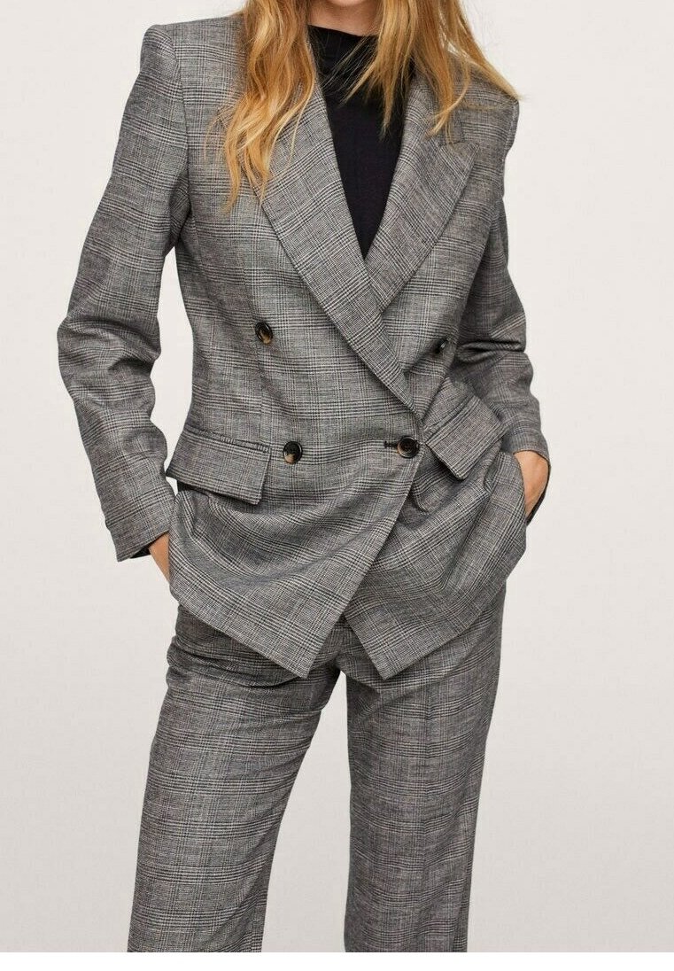 Szary garnitur w kratę z marynarką dwurzędową i dopasowanymi spodniami. Charakteryzuje się dużymi guzikami, strukturalnym kształtem i gładką fakturą.