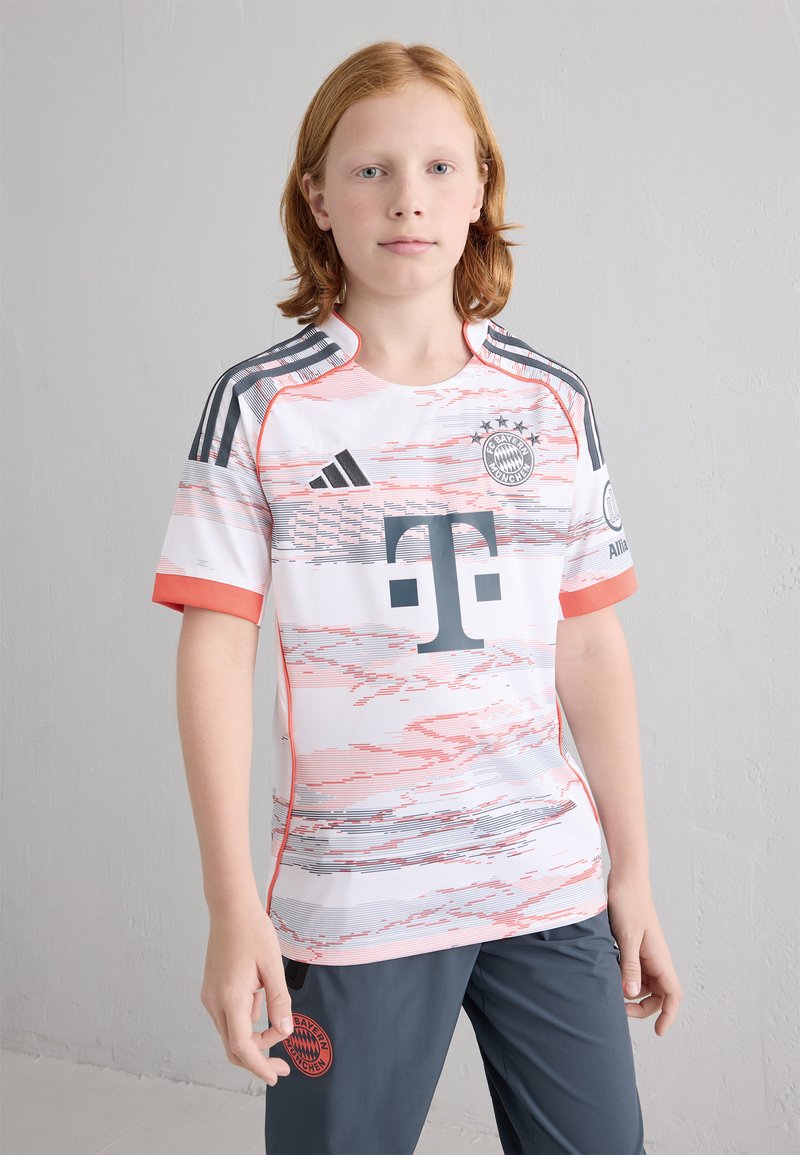 Hvit og rosa Bayern München-drakt med horisontale linjer, grå logoer og røde aksenter. Sammen med grå shorts med logo.