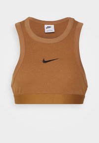 Brązowy sportowy biustonosz z prążkowanego materiału z czarnym logo Nike. Posiada okrągły dekolt i szerokie ramiączka zapewniające wsparcie. Gładka faktura, elastyczny materiał.