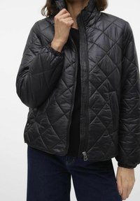 Černá prošívaná péřová bunda s stojáčkovým límcem, zapínáním na zip vpředu a elastickými manžetami. Má hladkou texturu a celoplošný vzor v podobě diamantů.
