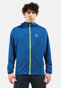 Blue athletic jacket with a hood, featuring a bright yellow zipper and elastic cuff details. Lightweight, smooth fabric, and simple design.