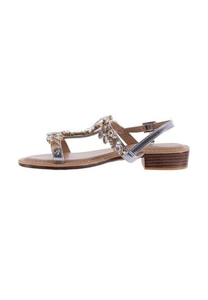 Sandalo con cinturino trasparente che presenta una suola piatta, decorato con accenti in oro e cristalli, che mette in mostra una soletta beige con tacco in legno marrone.