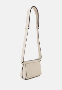 Borsa a tracolla in morbida pelle beige con bordi neri a contrasto, forma rettangolare, tracolla regolabile e scomparto principale con zip.