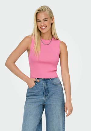 Enganliegendes pinkes Ripp-Top mit weiten Armausschnitten. Kombiniert mit locker sitzenden blauen Jeans aus Denim mit hoher Taille und entspanntem Schnitt. Schlichte Halskette aus Metall.