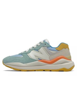 Lavtopet sneaker med hvid, lyseblå, teal ruskind, orange accent og gul sål, med hvide snørebånd og stor side logo.