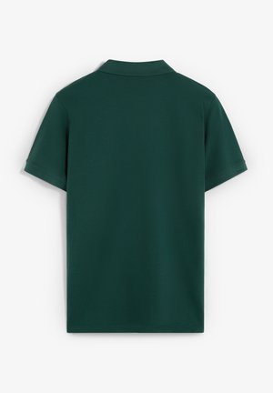 Camisa de polo de manga corta en verde oscuro con un cuello clásico, textura suave y un patrón limpio y liso, sin embellimientos visibles.