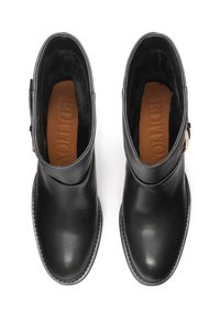 Botas de cuero negras hasta el tobillo con un acabado suave, punta redondeada y tacón bajo. Presentan una correa lateral y un detalle de hebilla. Interior forrado.