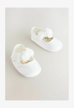 Bailarinas infantiles blancas con embellishments florales, tela suave, punta redondeada y forro interior con estampado. Diseño ligero y flexible.