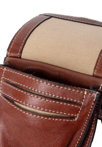 Brun läderplånbok med en slät yta, med ett beige tyginteriör, flera kortfack och vita sömnadsdetaljer.
