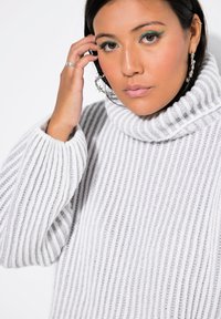 Grau geripptes Rollkragensweatshirt mit weicher Textur und lockerer Passform. Verfügt über einen hohen Kragen und weite Bündchen. Schlichtes, sauberes Design.