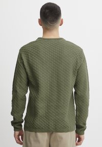 Olijfgroen gestructureerd gebreid sweater met een ronde hals, lange mouwen en geribbelde mouwen. Chunky, blokpatroon ontwerp overal.
