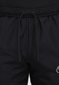 Schwarze Sportshorts aus glattem Stoff mit einem elastischen Bund, der eine verstellbare Kordel hat, und einem weißen Logo-Akzent am Bein.