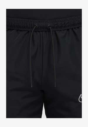Black athletic shorts made of smooth fabric featuring an elastic waistband with adjustable drawstrings and a white logo accent on the leg.