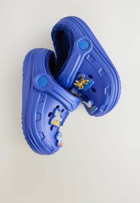 Kék gumibakancs, bolyhos belső résszel, bokapánttal, és színes állatformájú charms-al az oldalon. Texturált külső talp.