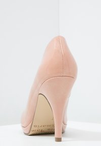 Růžová lodička na vysokém podpatku s hladkým, lesklým povrchem, špičatou špičkou a tenkým jehlovým podpatkem, s jemným prošíváním a neutrální podrážkou.
