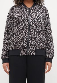 Kurtka bomberka w panterkę w odcieniach beżu i czerni. Posiada zamknięcie na suwak z przodu, ściągacze na mankietach i u dołu oraz miękki, teksturowany materiał.