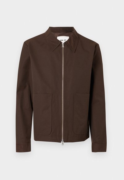 Καφέ μακρυμάνικο σακάκι με δύο μπροστινές τσέπες, ασημί φερμουάρ κλεισίματος και μυτερό γιακά κρεμα σμένο σε λευκό φόντο.