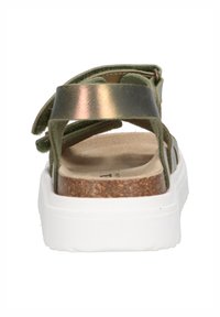 Green suede sandal with a shiny metallic strap, cork insole, and white rubber sole. Features crisscross strap design.