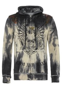 Capuchontrui met een verloop van zwart naar crème in een tie-dye patroon, met een grafische print, versleten randen en ritssluiting.