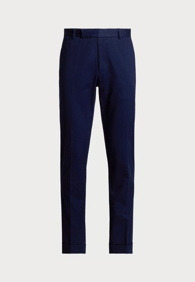 Pantalones de vestir azul marino hechos de tela texturizada, con frente plano, pasadores para cinturón y un diseño de pierna recta con puños doblados.