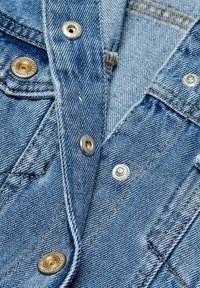 Denimskjorta med ljusblått tyg, synliga sömmar, silver- och guldknappar samt en klassisk kragdesign.