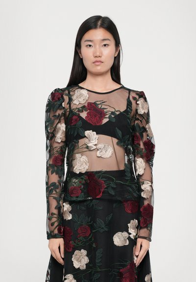 Sheer black dress with long sleeves, featuring intricate red and beige floral embroidery. Transparent fabric overlays solid black sections.