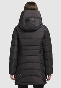 Veste rembourrée noire avec un col haut et une grande capuche, présentant des sections matelassées horizontales et un logo au niveau du cou. Texture lisse et brillante.