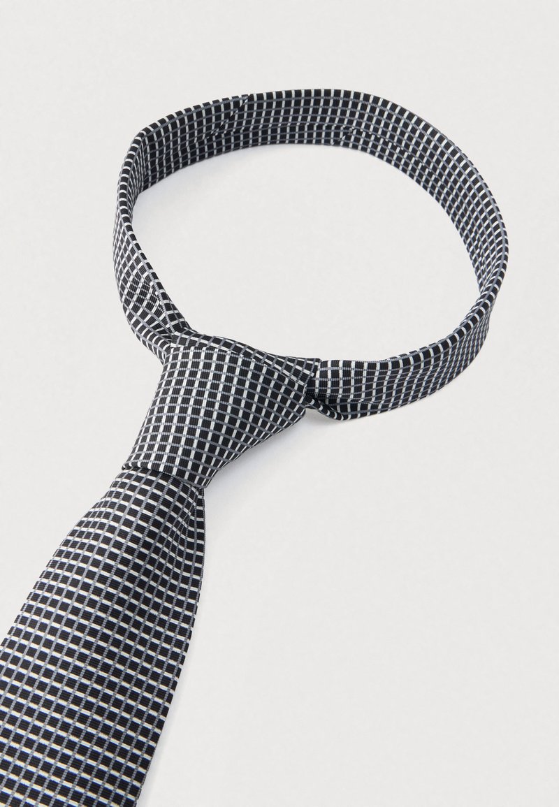 Black and white checkered tie, featuring a square pattern. Smooth texture, tapered end, and a classic knot for secure wear.