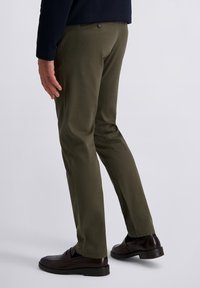 Olijfgroene broek van gladde stof, met een slim fit, standaardzakken en een enkele achterknopdetail. Gemaakt in combinatie met donkere instappers.