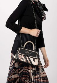Borsa in materiali misti con parte superiore in pelle nera, motivi rosa chiaro e tracolla a catena. Accento decorativo con logo sulla parte anteriore.