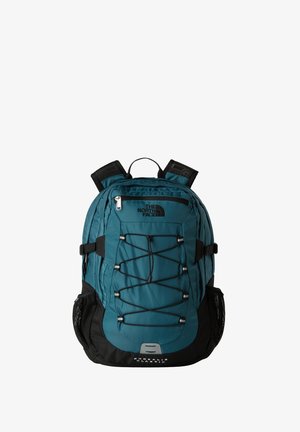 Mochila en tonos azul verdoso y negro con un bolsillo frontal con cremallera, diseño de cordón elástico, bolsillos laterales de malla, correas acolchadas y un asa superior.