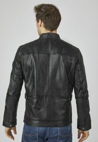 Schwarze Lederjacke mit taillierter Passform, strukturiertem Finish und Schulterakzenten. Mit Stehkragen und Druckknopfdetails.