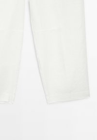 White linen pants with a relaxed fit, featuring a smooth texture, straight leg design, and seams running along the outer sides.