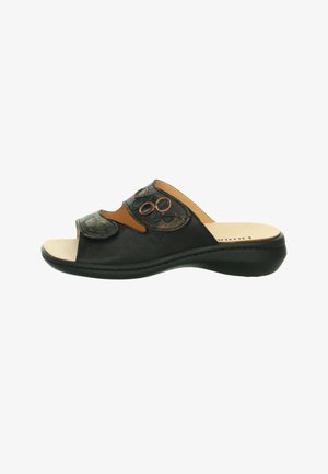 Zwarte open-teen slideslipper met een gestructureerd oppervlak, decoratieve ronde accenten en een gevoerde beige binnenzool op een zwarte zool.