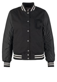 Chaqueta varsity negra con botones de presión, cuello, puños y cinturilla a rayas, y una gran letra "C" texturizada en el pecho.