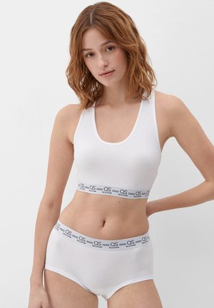 Witte katoenen bralette en bijpassende boyshorts met een zwart logo band. Gladde textuur, aansluitend ontwerp en minimalistische stijl.