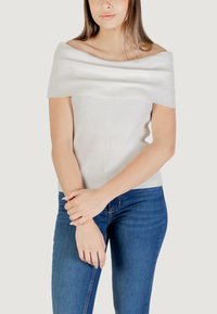 Top a spalle scoperte in grigio chiaro, dalla forma aderente, con maniche corte e una texture liscia, abbinato a jeans in denim blu.