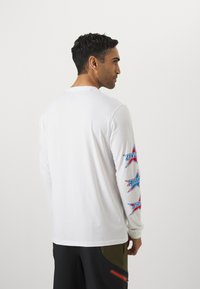 Under Armour STACKED STARS  - Top dugih rukava - white/red