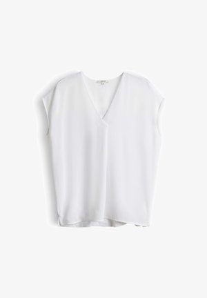 Blusa bianca senza maniche con scollo a V e vestibilità ampia, mostrata distesa su sfondo bianco.