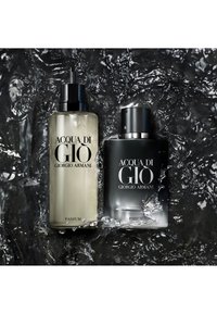 To flasker Acqua di Giò Giorgio Armani parfyme, en klar med pumpe, en svart med spray, omgitt av sprutende vann.